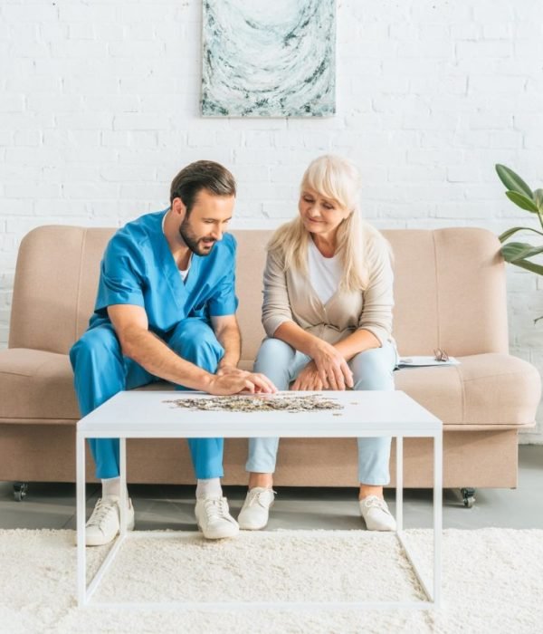 smiling-senior-woman-and-young-social-worker-playing-with-jigsaw-puzzle.jpg